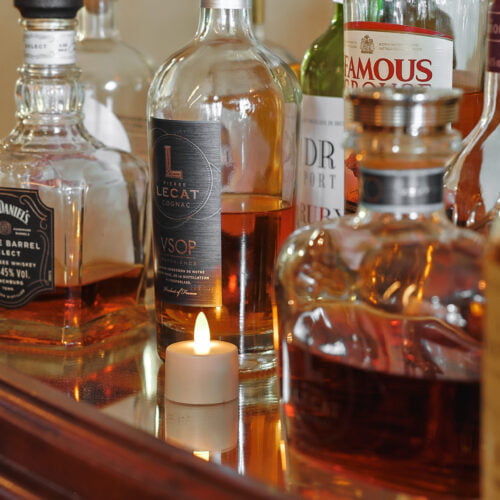 Mooie waxinelichtjes in een glazen waxinelichthouder op een dranktafel
