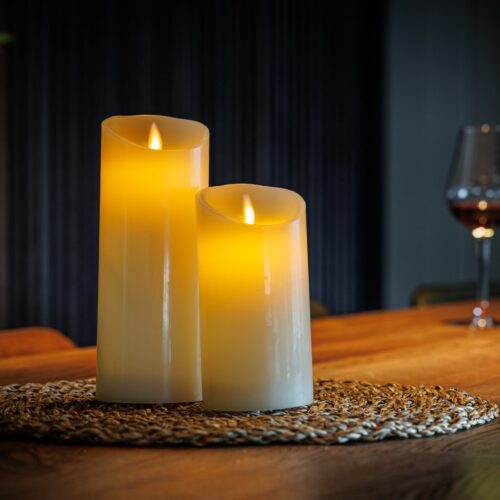 twee led kaarsen op een placemat op tafel met op de achtergrond een wijnfles en glas