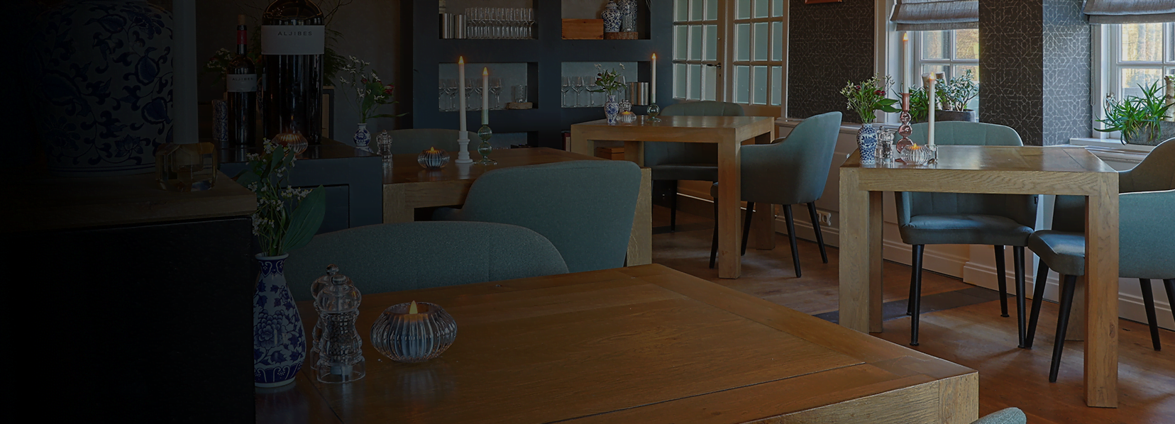 Een restaurant met op alle tafels een waxinelichthouder met daarin oplaadbare led waxinelichtjes